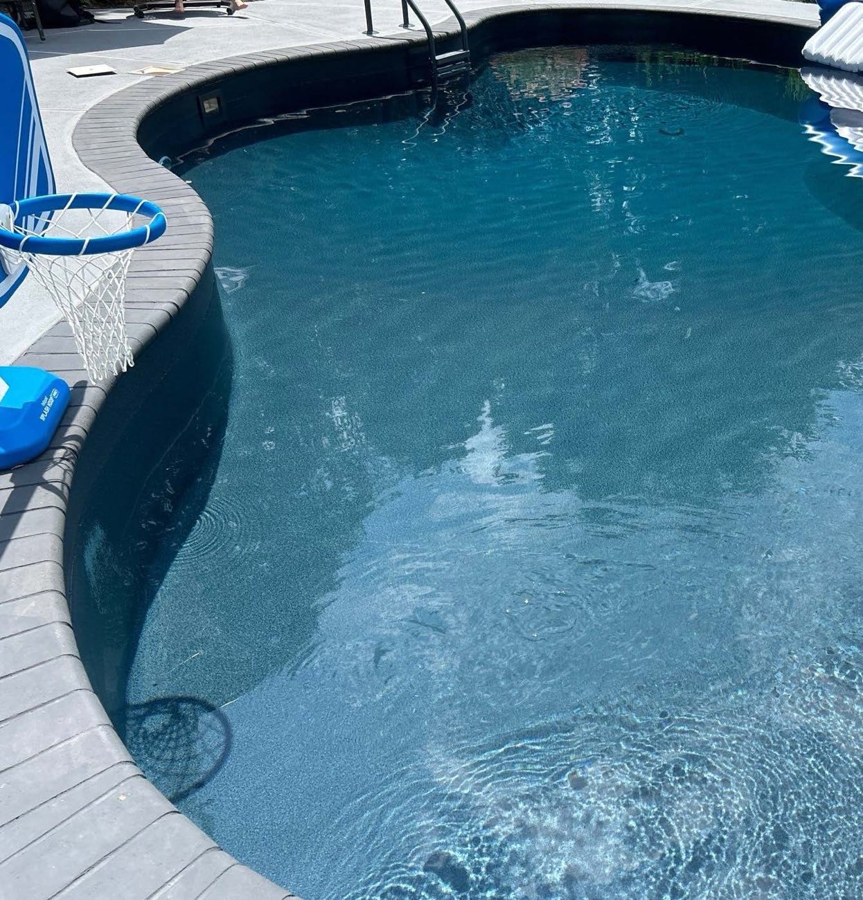 Curved pool with a new blue mosaic vinyl liner