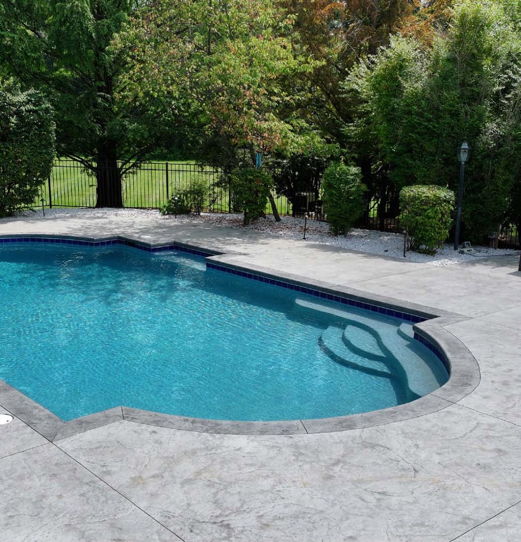 Renovated pool with gray coping and stamped deck